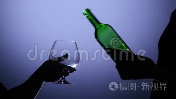 侍酒师倒红酒杯。 背光灯