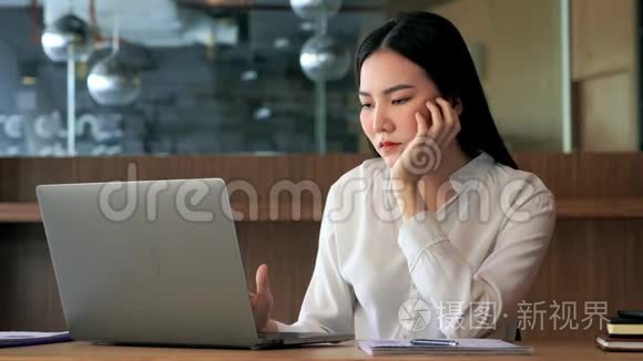 4k视频：迷人的疲惫的亚洲商界女性在办公室感到悲伤、无聊、忧郁、不快乐、懒惰