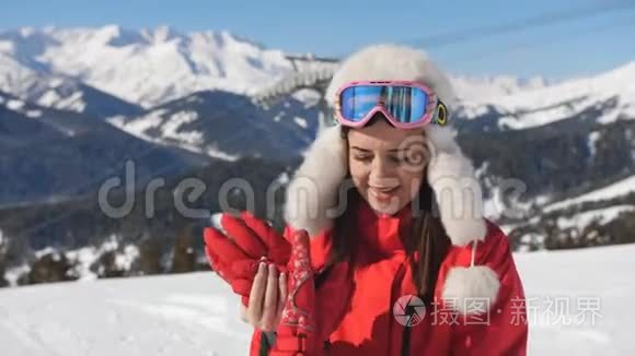 女滑雪者戴着手套和滑雪护目镜，拿起他的滑雪杆，开始下山。