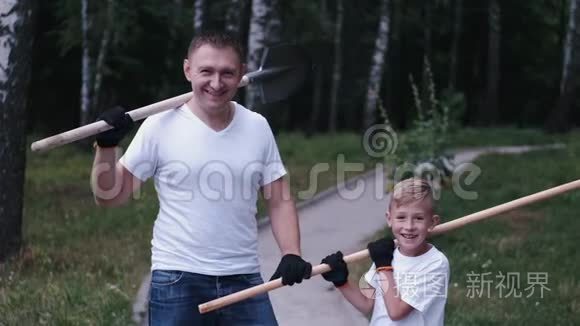 快乐的园丁父亲和儿子正拿着工具站着