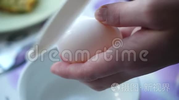 女人的手把鸡蛋打碎成白色的碗视频