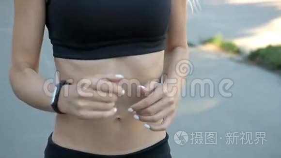 美丽健康的金发女子道路与健身追踪器