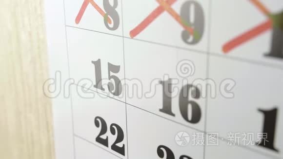 女性手在日历日15日用红色标记交叉。 慢镜头。 关门