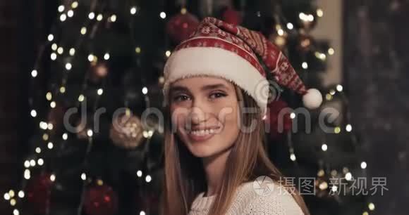 戴着圣诞帽的年轻白种人美丽微笑的肖像站在科西的圣诞树旁