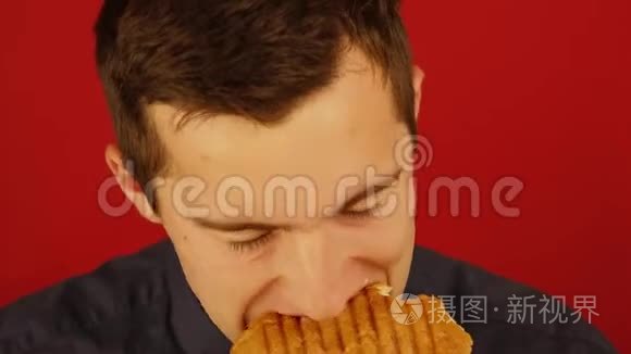 一个人在红色背景下努力吃汉堡视频