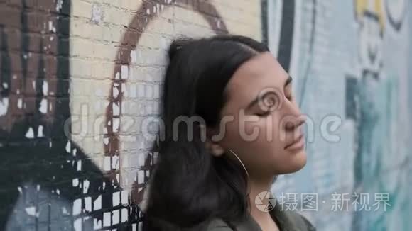 伤心的黑发女孩用涂鸦滑下墙视频
