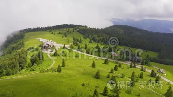 前方空中覆盖着绿草和森林覆盖的青山，朝道路和建筑与停放的汽车。 黑森林