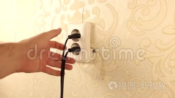 人从插座上选择2根电线.. 撕破的墙纸