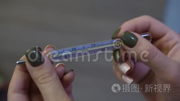 女孩拿着一个玻璃水银温度计视频