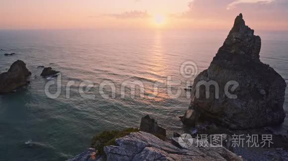 4K日落在普拉亚大乌尔萨乌尔萨海滩，辛特拉，葡萄牙。 巨大的岩石在大西洋的黄昏升起金色的晚霞