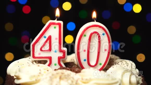 在蛋糕上面的40号-40岁生日蜡烛燃烧-在最后吹灭. 彩色模糊背景短视频