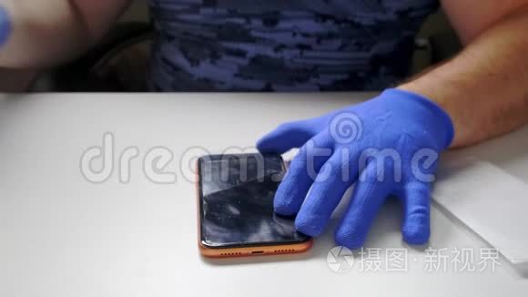 一只男性的手替换了一个破碎的钢化玻璃屏幕保护器，用于智能手机。