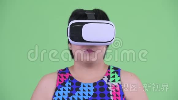 使用虚拟现实耳机的快乐年轻超重亚洲女人的脸