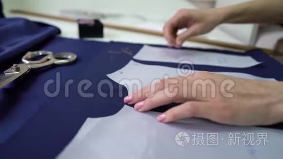 裁缝手把纸样钉在织物上视频