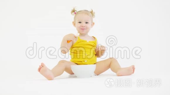 欢快的女婴在白色背景下吃饭视频