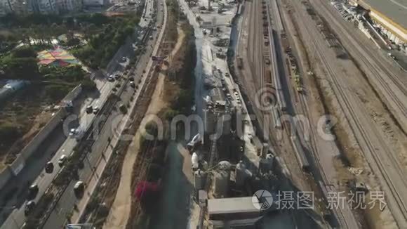 在水泥厂上空高空钻. 卡车装载和浇筑沙子。 建筑工业用地