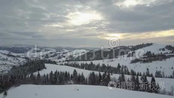 日出时飞越喀尔巴阡山的一个村庄。 鸟山上白雪覆盖的房子的视野。 农村