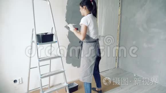 女工人用抹刀在公寓或房子里涂上装饰石膏。 建筑修理和翻新