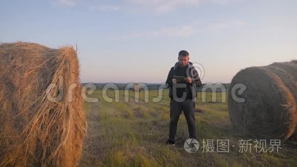 青年农民在田间手持平板电脑，并利用技术预测未来农业增长。 智能智能智能