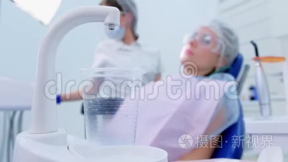 根据医生和病人的背景，在口腔诊所的玻璃中浇水。