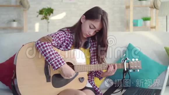 一个美丽的亚洲女孩，留着长发，在一个现代家庭的客厅里，很难学会演奏声学音乐