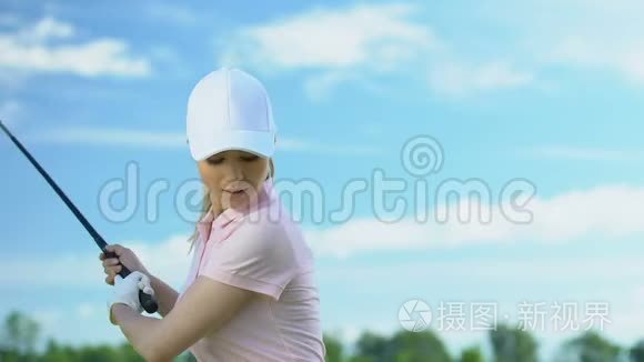紧张的女子训练在乡村球场挥球打高尔夫球