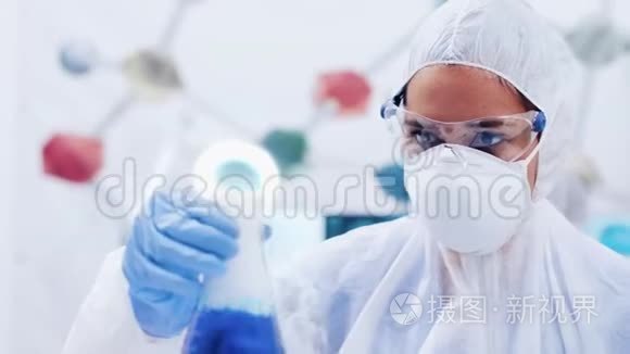女科学家用蓝色液体摇动瓶子视频