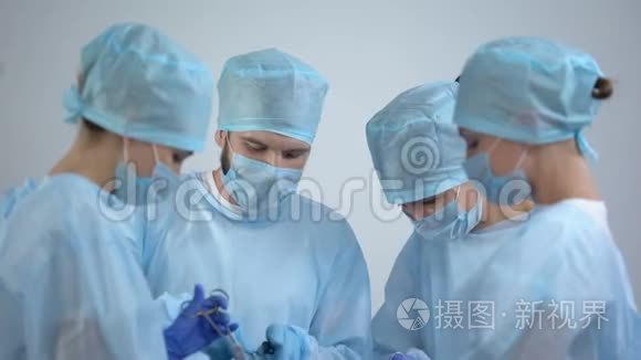 在手术室工作的外科医生团队，护士检查监视器上的心电图率