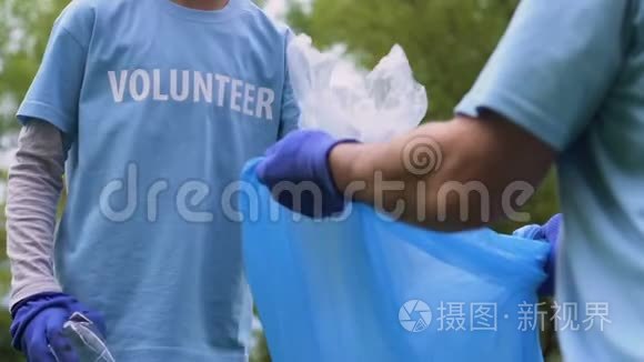 快乐的小志愿者把塑料垃圾放进垃圾袋，打扫城市公园