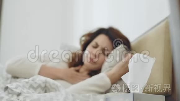 病妇得了咽喉病毒躺在床上。 特写女性手拿餐巾