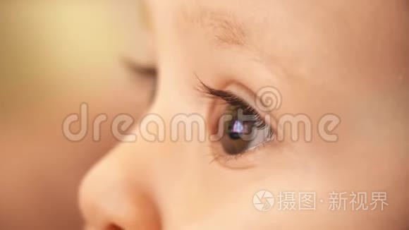 电脑屏幕上的未知卡通反映在婴儿的眼睛里。 特写镜头