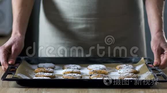 女人在镜头前展示烤盘和巧克力饼干，特写