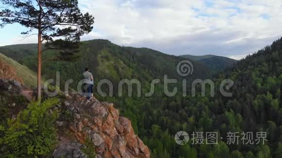 一对年轻夫妇站在悬崖边欣赏美丽的景色。