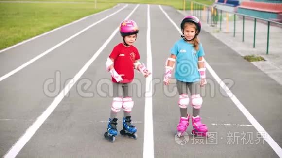 两个女孩在学校体育场学溜冰鞋