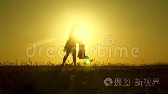 妈妈在阳光下和女儿玩。 父母和小女儿玩。 快乐的孩子和他的母亲在公园散步。