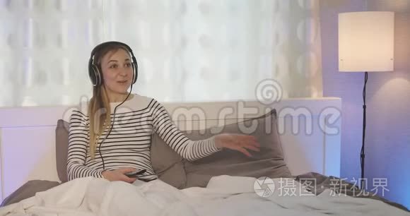 一个幸福的家庭。 戴着耳机听音乐的快乐女人。