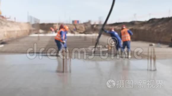 建筑工人在建筑地面上浇筑混凝土