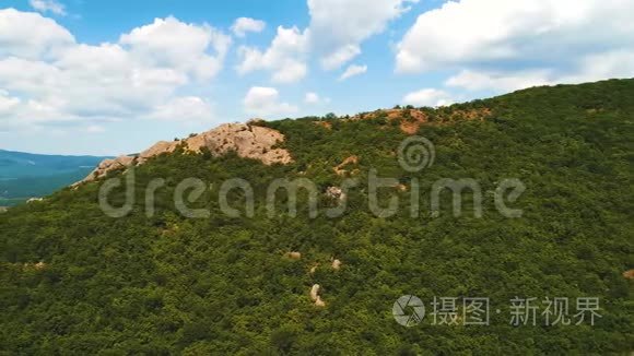 年，在蔚蓝多云的天空下，青翠的树木和灌木丛覆盖着高山，令人叹为观止