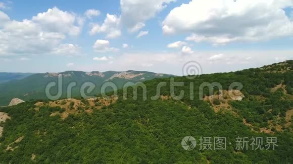 年，在蔚蓝多云的天空下，青翠的树木和灌木丛覆盖着高山，令人叹为观止