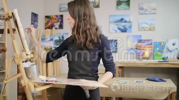 年轻女子正在艺术工作室学习画画，在画布上画画