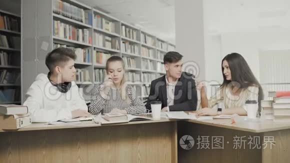 青年学生在大学图书馆聊天。