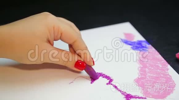 女人的手在白纸上画着紫色的彩纸上的晚霞