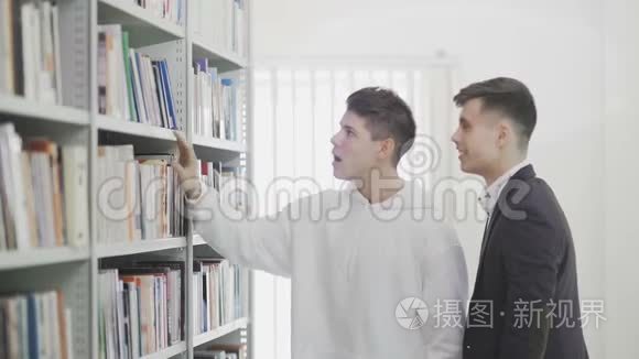 当他们中的一个找到书的时候，快乐的大学生笑着拥抱