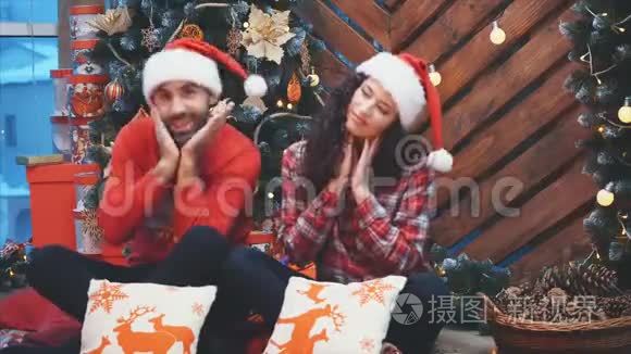 一对夫妇在圣诞树旁享受圣诞心情和乐趣的视频。