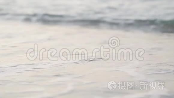 画面中绿松石泡沫般的波浪滚向沙滩.. 海滩上迷人的海洋或海洋。 美丽的土耳其自然。