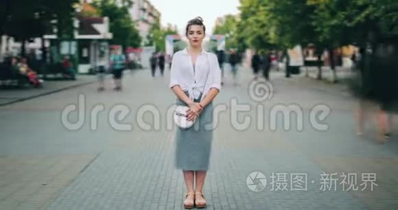 在繁忙的街道上站在市中心的有魅力的成年女性的时间流逝