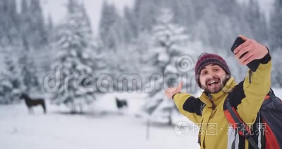 微笑的游客带着马在山中央和雪林里自拍，他很高兴拍照片