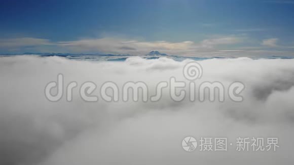 神奇的无人机飞行在漂浮的云层之上，有山景。 超脱