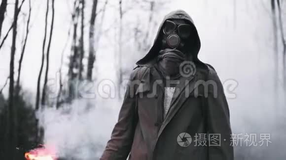 戴着防毒面具的人站在空寂的森林里，手里拿着红色的信号火