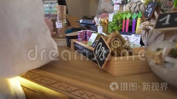 女性买家使用终端和信用卡在礼品店支付商品。 特写度假纪念品信用